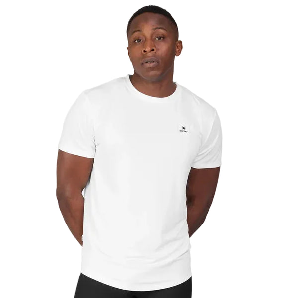 En mand har en Saysky Clean Combat Pro T-shirt (herre) på samt hvide og sorte bukser og står foran en lysegrå baggrund med armene bag ryggen.