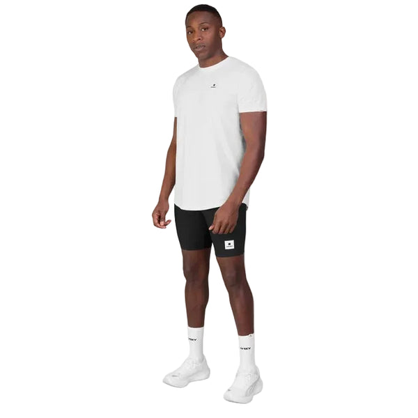 En mand står med ansigtet vendt mod kameraet iført en hvid Saysky Clean Combat Pro T-shirt, sorte shorts, hvide sokker og hvide sneakers foran en helt enkel hvid baggrund.