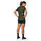 En kvinde med hestehale kigger væk fra kameraet iført en grøn Saysky W Clean Pace T-shirt (Dame) fremstillet af svedtransporterende genbrugspolyester, parret med sorte shorts, sokker med hvid tekst og sorte løbesko på en hvid baggrund.