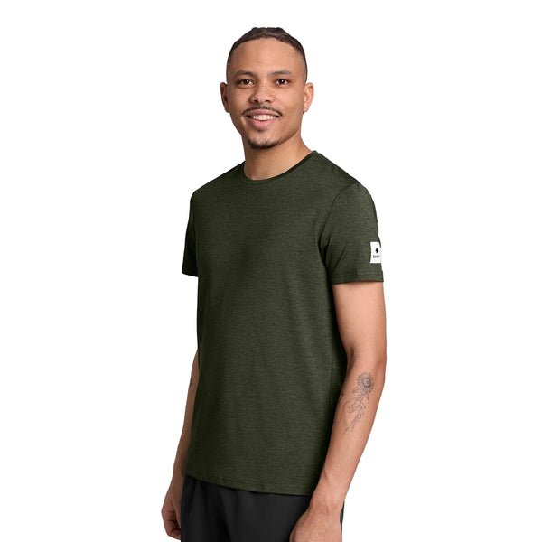 En smilende mand iført en mørkegrøn Saysky Clean Pace-T-shirt med et hvidt logo-mærke på venstre ærme.