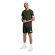 En mand iført en grøn Clean Pace-T-shirt, sorte shorts, hvide sokker og hvide sportssko.