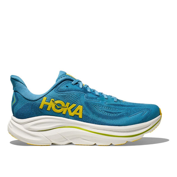 Hoka Clifton 10 herre løbesko i Alpine Blue/Foggy Night har et gult logo, en tyk hvid sål og gule detaljer. Skoen vises i sideprofil mod en ren, hvid baggrund.
