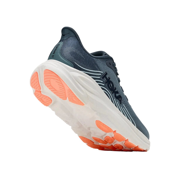 En enkelt Hoka Clifton 11 dame-løbesko i farven Faded Navy / Glimmering Blue, med maksimal støddæmpning, en tyk hvid sål og orange gummisål, set fra bagsiden og isoleret på en hvid baggrund.