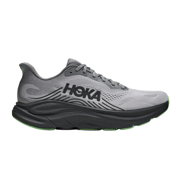 En Hoka Clifton 11 herresko i farven Galactic Grey / Stardust, med maksimal stødabsorbering, en tyk og polstret sål, overdel i mesh og et markant sort HOKA-logo på siden. Ydersålen har et strejf af grønt, der kan ses nederst.