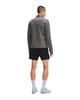 En mand står med ryggen til kameraet iført en grå On Climate Shirt 3, Herre, Ember – en perfekt løbetrøje til mænd i koldt vejr – sammen med sorte shorts, hvide sokker og grå løbesko. Han står foran en ensfarvet hvid baggrund.