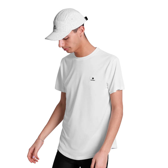 En person iført Saysky Combat Cap, Unisex, White Universe og en almindelig hvid t-shirt med et lille sort logo står på en hvid baggrund og kigger ned og til siden.