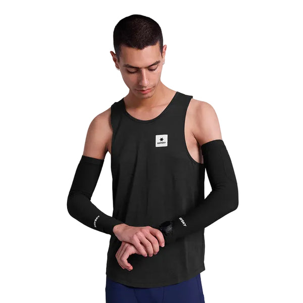 En person iført en sort ærmeløs tanktop og Saysky Combat Rib Sleeves (Unisex, Black) kigger ned, mens han justerer et smartwatch på håndleddet mod en almindelig hvid baggrund.