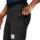 En mand i sorte Saysky Combat+ Rib Running Short Tights 8 lægger en sort smartphone i lårlommen. Hans hånd med en sølvring viser det praktiske design og bevægelsesfrihed i disse løbetights.