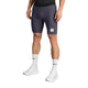 En person har Saysky Combat+ Rib Short Tights 8″ til mænd i gråt på, en sort overdel, hvide strømper med sort tekst og hvide sportssko. Shortsene har et lille, rektangulært, hvidt mærke på det ene ben. Kun underkroppen er synlig.