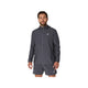 En mand med kort brunt hår og skæg har ASICS Core Jacket til mænd i farven Carrier Grey på – en vandafvisende jakke fra ASICS, der er designet med fokus på komfort. Han har den på sammen med et par matchende shorts og står med ansigtet vendt fremad, venstre arm let afslappet og højre hånd langs siden, foran en ensfarvet hvid baggrund.