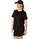 En kvinde iført ASICS Core Ss Top, Dame, i farven Performance Black står let vendt til siden foran en ensfarvet hvid baggrund. Hun har kombineret toppen med matchende sorte shorts og en sort kasket. Både toppen og shortsene er forsynet med et lille hvidt ASICS-logo.