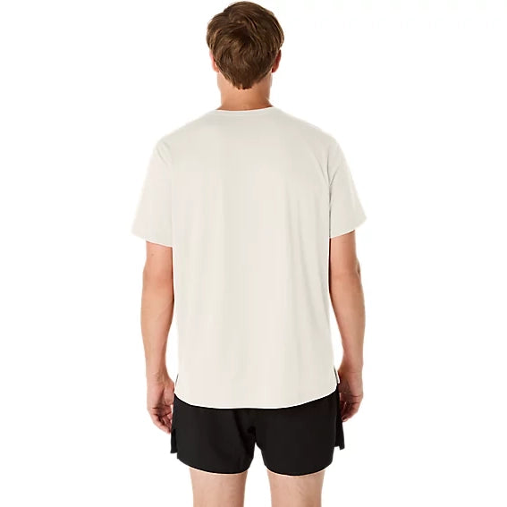En person står med ryggen til kameraet iført en cremefarvet Core Ss Top, Herre fra Asics og sorte shorts foran en hvid baggrund.
