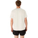 En person står med ryggen til kameraet iført en cremefarvet Core Ss Top, Herre fra Asics og sorte shorts foran en hvid baggrund.