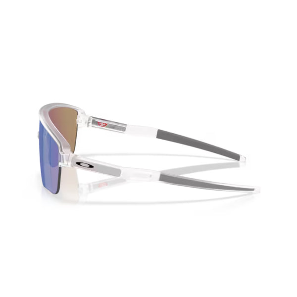 Et par Oakley Corridor SQ-solbriller i Matte Clear med gråtonede stænger, Prizm Sapphire-linser og UV-beskyttelse. Oakley-logoet ses på venstre brillestang. Set fra siden på en hvid baggrund.