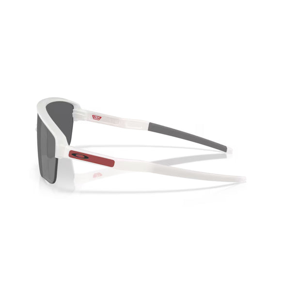 Oakley Corridor SQ-solbriller i Matte Vapor har Prizm Black-glas, hvidt gennemsigtigt stel, sorte ørestykker, en rød rektangulær sidedetalje med et sort Oakley-logo, et indvendigt USA-flagmærke og UV-beskyttelse.