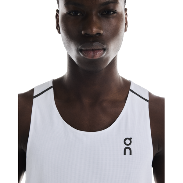 En herre ses fra skuldrene og opefter iført On Performance Tank, Herre, White/Silver, med et lille ON-logo på venstre bryst - ideelt til løbetræning - på en hvid baggrund.