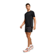 En mand i On Performance-T, Herre, Black/Eclipse, sorte shorts og hvide løbesko med orange detaljer går mod en hvid baggrund. Den ultralette, åndbare Performance-T garanterer optimal komfort ved hvert skridt.