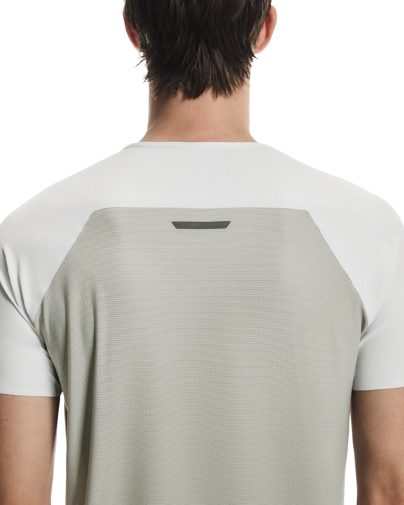 En person ses bagfra iført On Performance-T, Herre, Iceberg/Tin. Den kortærmede skjorte har et lysegråt rygpanel, hvide ærmer og en lille mørk rektangel-detalje øverst på ryggen.
