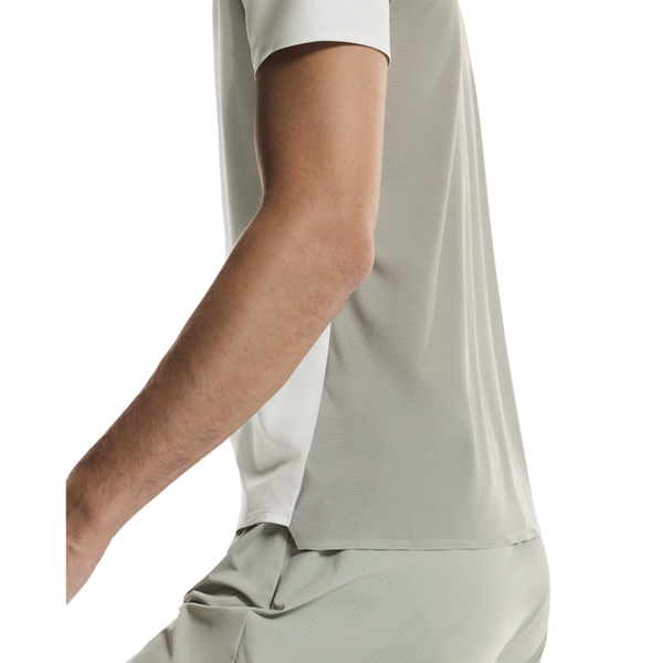 En person iført On Performance-T, Herre, Iceberg/Tin er vist fra skulder til lår, set fra siden mod en almindelig baggrund.