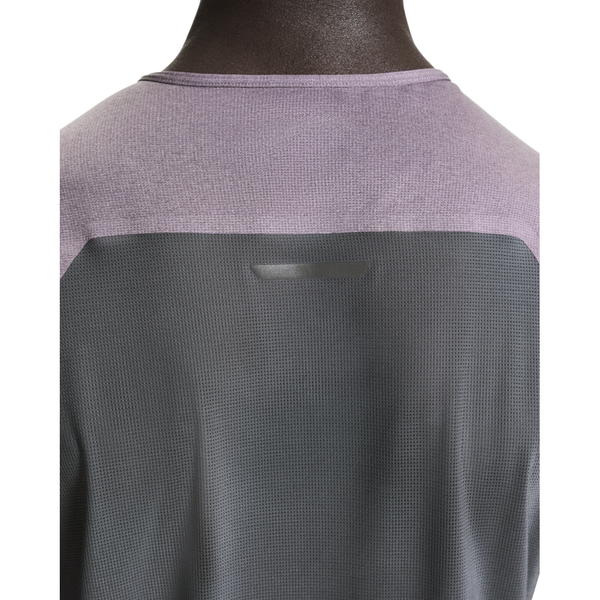 Nærbillede af en person iført On Performance-T, Herre, i Dewberry/Eclipse. Det lette, strukturerede stof dækker nakke og skuldre og er designet til at være åndbart og svedtransporterende.