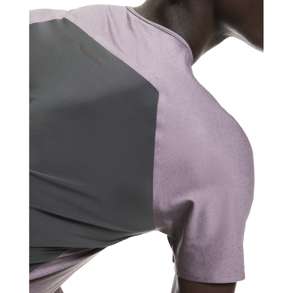 En mand ses fra skuldrene og op, lænet forover, iført On Performance-T, Herre i Dewberry/Eclipse med mørkegråt rygpanel. Baggrunden er helt hvid.