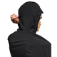 En mand iført On Core Jacket, Herre, Black, ses bagfra og fra siden, mens han justerer hættens løbegang med den ene hånd.