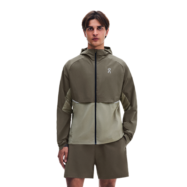En mand iført en tofarvet olivengrøn Core Jacket, Herre, Bark/Vetiver og matchende shorts.