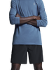 En person med armene over kors er iført en blå sportstrøje med lange ærmer og ON 7 Performance Shorts, Herre, Sort, foran en ensfarvet hvid baggrund. Ansigtet kan ikke ses.