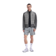 En mand iført en On Weather Hybrid-jakke, Herre, Eclipse/Ember, grå sportsshorts, hvide sokker og lyse sneakers.