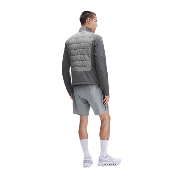 En mand set bagfra, iført en grå On Weather Hybrid-jakke, lysegrå shorts, hvide sokker og hvide løbesko.