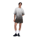 En mand står foran en hvid baggrund iført en grå og hvid T-shirt med farveovergang, ON Performance Volt Shorts Herre Espresso, hvide sokker med et lille logo og sorte sportssko. Den ene arm har han bag ryggen.