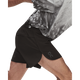 En person iført en mønstret grå sportstrøje og ON Performance Volt-shorts i farven Herre, Espresso strækker sig fremad og fremhæver dermed komforten ved disse ON-shorts.