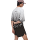 En person iført en lysegrå og hvidmønstret skjorte, ON Performance Volt Shorts Herre Espresso, en lyserød kasket og solbriller står foran en ensfarvet hvid baggrund med ryggen til og den ene hånd bag ryggen.