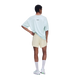 En person ses bagfra iført en lyseblå oversized T-shirt og ON Performance Volt Shorts, Herre, Hare – vandafvisende løbeshorts – kombineret med hvide sokker og sneakers foran en ensfarvet hvid baggrund.