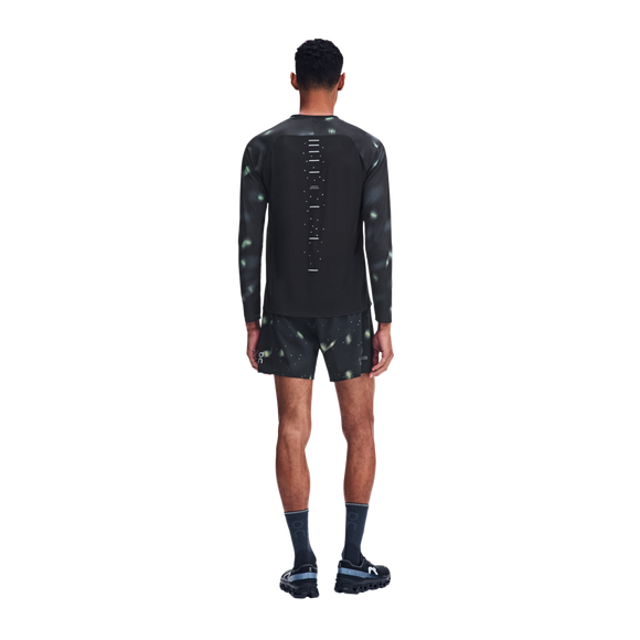 En mand set bagfra, iført en sort Performance Long-T Lumos 3-træningstrøje med reflekterende mønstre og matchende shorts.
