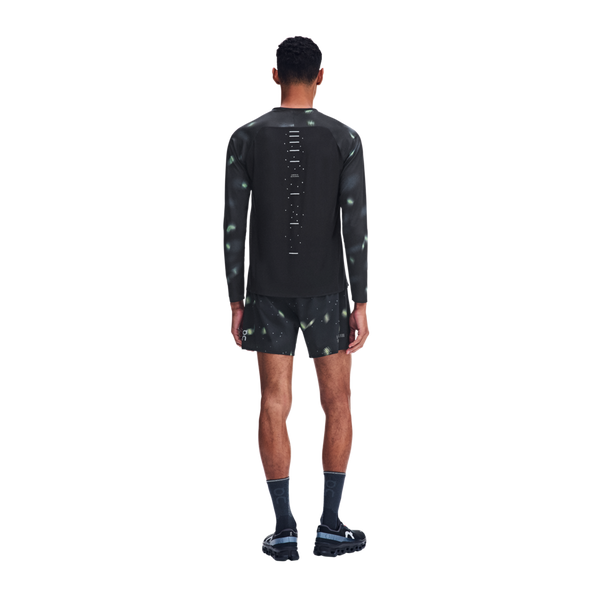 En mand set bagfra, iført en sort Performance Long-T Lumos 3-træningstrøje med reflekterende mønstre og matchende shorts.