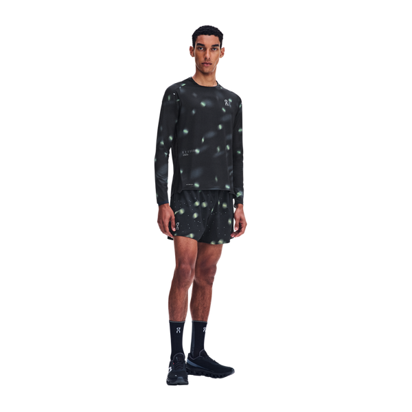 En mand viser de sorte Performance Shorts Lumos, Herre, med et reflekterende, plettet mønster.