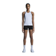 En person står med ansigtet fremad i On Performance Tank, Dame, White/Silver, sorte shorts, hvide sokker og hvide sportssko mod en almindelig hvid baggrund - ideelt hurtigtørrende træningstøj til enhver træning.