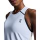 Nærbillede af en kvinde iført On Performance Tank, Dame, White/Silver med et lille sort logo på brystet. Hendes ansigt er delvist synligt mod en hvid baggrund.