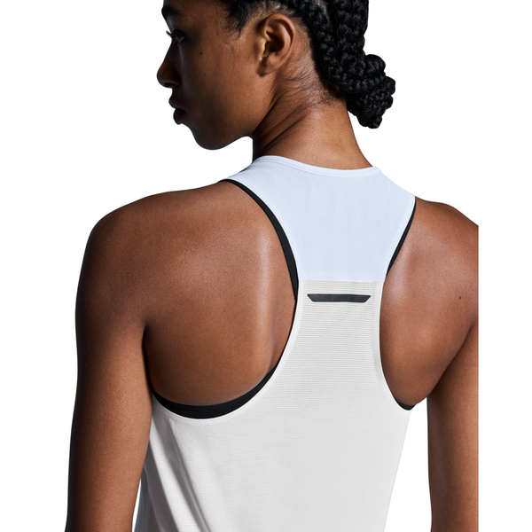 En kvinde med flettet hår ses bagfra iført On Performance Tank, Dame, White/Silver. Den hvide tank har sort kant og en lille sølvdetalje nær halsudskæringen. Dens hurtigtørrende stof er perfekt til hurtigtørrende træningstøj. Hvid baggrund.