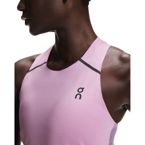 En person iført en On Performance Tank, Dame, i Sakura/Dewberry med et lille logo på brystet. Billedet er beskåret, så det viser overkroppen og en del af ansigtet mod en almindelig hvid baggrund.