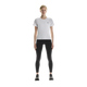 En person står med ansigtet vendt fremad iført en ON Performance-T, Dame, hvid/sølv, kombineret med sorte leggings og sorte sportssko, foran en ensfarvet hvid baggrund.