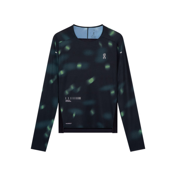 Black On Performance Long-T Lumos, Dame – løbetrøje med grønt plettet mønster, asymmetrisk nedkant og reflekterende detaljer.
