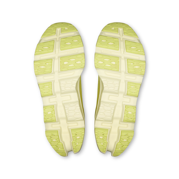 Et par On Cloudmonster 3 herre løbesko i Limelight/Seedling vises nedefra og afslører en segmenteret slidbane med rektangulære og diamantformede greb. Den almindelige hvide baggrund fremhæver deres avancerede CloudTec-dæmpning.