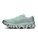ON Cloudmonster 3 herresko i farvekombinationen Brook/Flurry ses her set fra siden og fremstår i lysegrå nuancer med mintgrønne detaljer, en overdel i mesh, CloudTec-støddæmpning og et segmenteret såldesign på hvid baggrund.