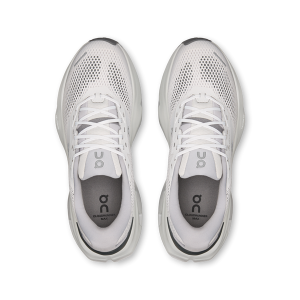 Et billede set ovenfra af et par On Cloudrunner 3 Max herreløbesko i farven Frost/Rock, med en overdel i atletisk mesh, hvide snørebånd og mørkegrå indlægssåler med On-logoet. Placeret side om side på en hvid baggrund fremhæver disse løbesko maksimal komfort til hver eneste løbetur.