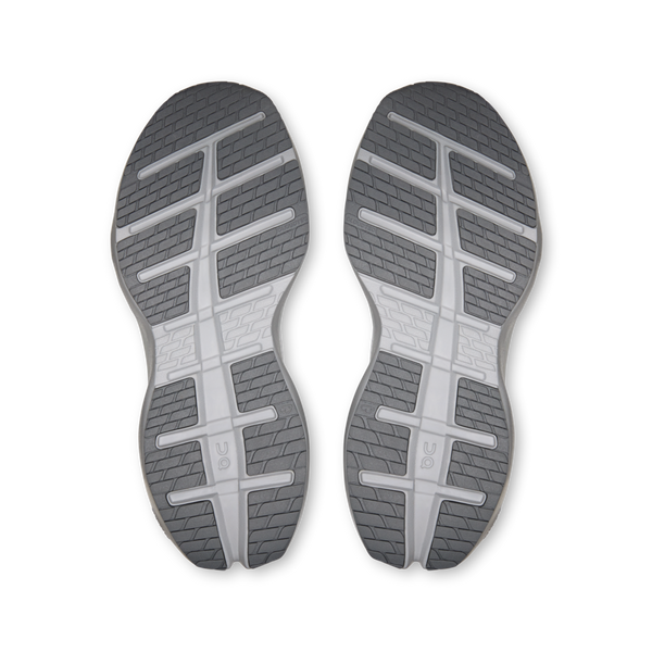To grå skosåler fra On Cloudrunner 3 Max, Herre, Frost/Rock vises side om side og fremviser strukturerede mønstre og riller, der sikrer maksimal komfort og greb. Sålerne har geometriske mønstre og On-logoer tæt på midten, alt sammen på en ensfarvet hvid baggrund.