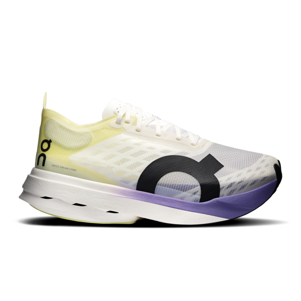 Et nærbillede fra siden af On Cloudboom Strike Dame løbesko i Juniper/Limelight med en gennemsigtig overdel, et fedt O-logo, hvide snørebånd og en tyk sål, der går fra grøn til gul.