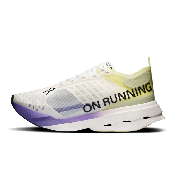 On Cloudboom Strike Dame i Juniper/Limelight har en overdel i gennemsigtigt mesh, grønne og gule detaljer, ON RUNNING-branding på siden og en karakteristisk udskåret sål, hvilket gør den til den perfekte konkurrencesko til løbsdagen.