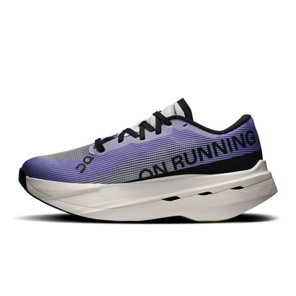 Et nærbillede fra siden af On Cloudboom Volt løbesko dame i Juniper/Limelight med sorte snørebånd og branding på siden. Den tykke, polstrede sål med sorte detaljer gør den ideel til tempotræning.